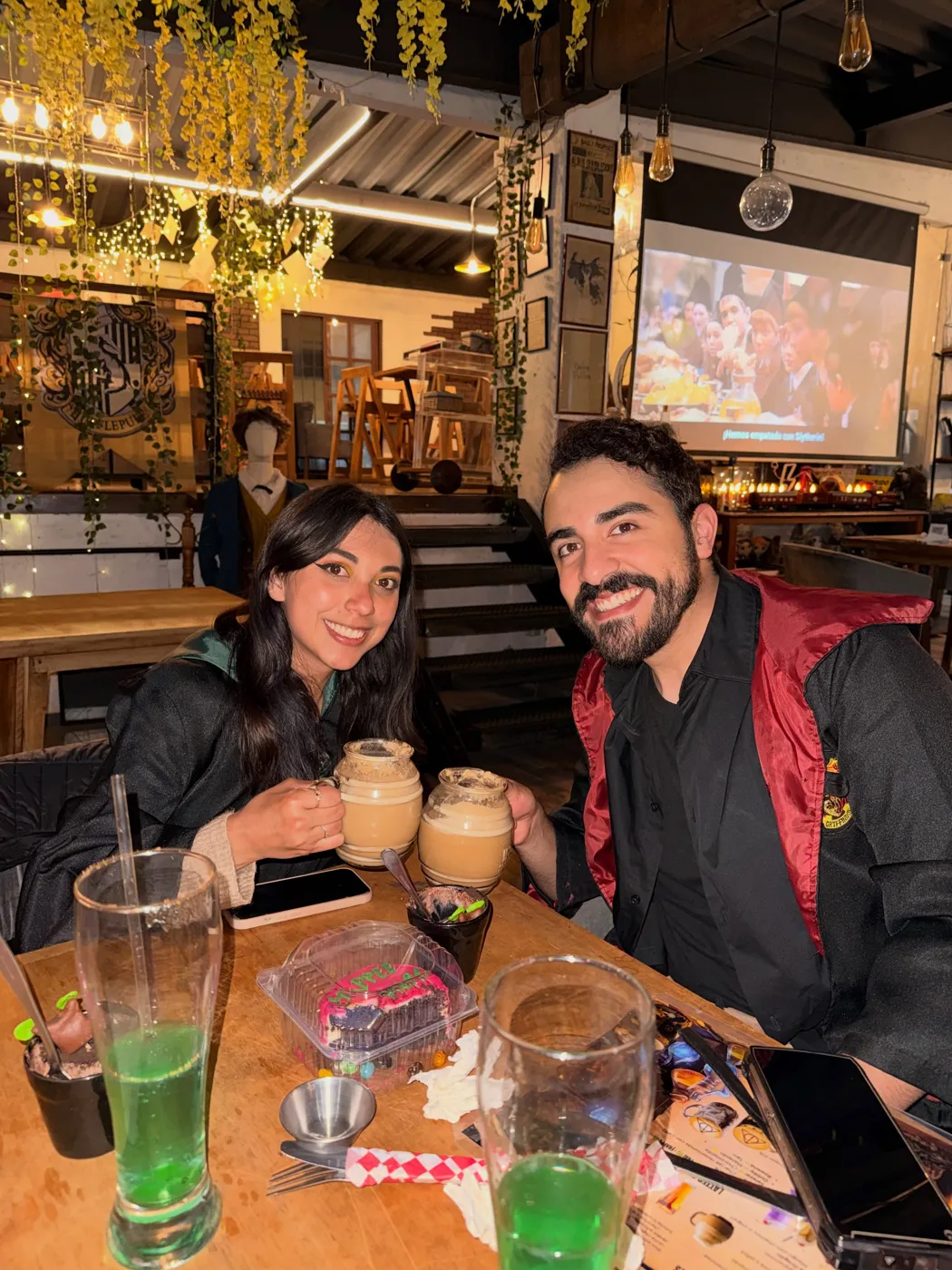 Mesa con bebidas verdes en vasos altos y tarros con espuma